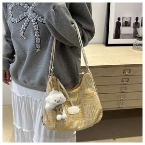 Detail of yellow checkered tote bag with white strap and cute cloud charm accessory