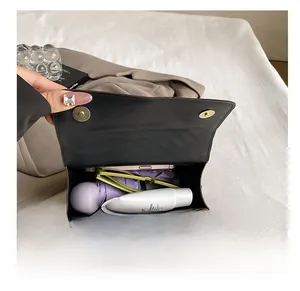 Close-up of the spacious interior of the black leather bag holding daily essentials