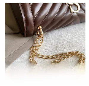 Close-up of quilted coffee leather crossbody bag with elegant gold chain and Y-logo detail