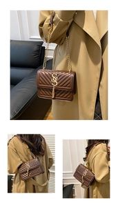 Detail view of brown quilted crossbody bag with gold metal logo and fringe chain strap