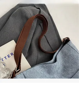 Top-down view of blue denim tote bag with brown woven handles and durable fabric texture