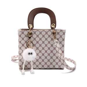 Chic cream tote bag with brown monogram pattern and plush charm for women
