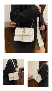 Detail of white quilted crossbody bag featuring gold hardware and elegant tassel detail