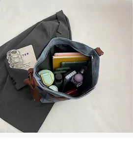 Spacious interior of denim tote bag showing capacity for laptop, water bottle, and daily items