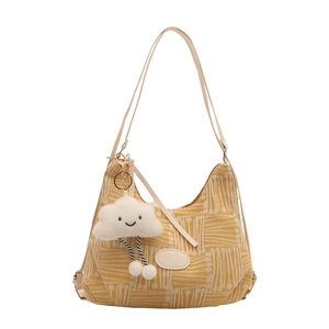 Yellow canvas shoulder bag with white radial patterns and a plush cloud charm accessory