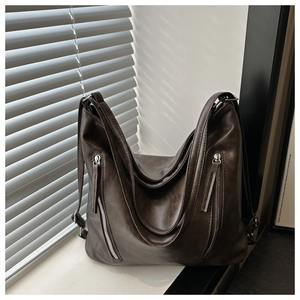 Détail du sac Hobo en similicuir marron avec double fermeture éclair et texture souple