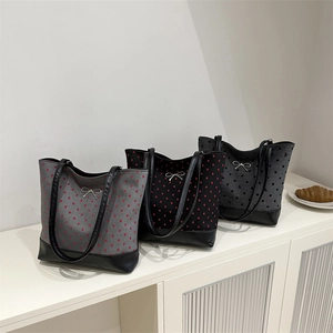Three canvas tote bags with heart and polka dot prints and black leather handles