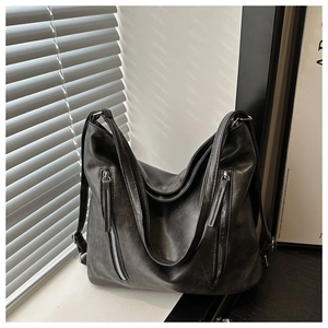 Détail du sac hobo en similicuir noir mat avec double fermeture éclair et ombre naturelle