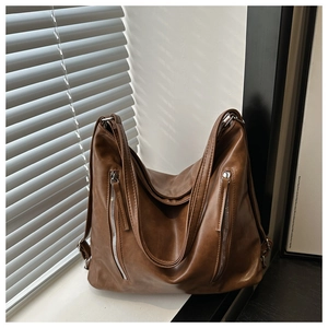 Gros plan sur un sac vintage en cuir PU marron avec texture litchi et poches à fermeture