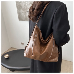Dettaglio borsa hobo vintage in pelle PU marrone con doppie cerniere argentate verticali