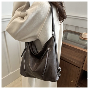 Detail of vintage brown leather tote bag with functional double vertical metal zippers