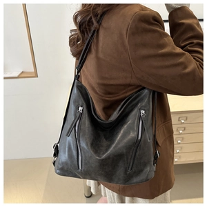 Detail of black large capacity hobo bag featuring stylish dual vertical silver zippers