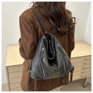 Detail of soft black leather backpack showing metallic zipper and side texture