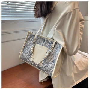 Detail of grey pleated tote bag with pearl chain and fashion slogan on front pocket