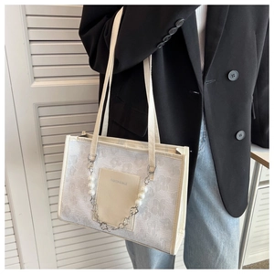 Detail of white floral tote bag with pearl chain strap and front fashion pocket