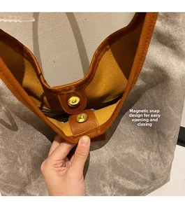 Gros plan sur la fermeture magnétique d'un sac cabas en toile grise avec doublure