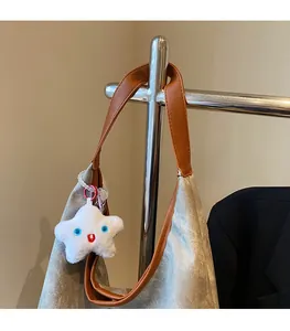 Détail du grand sac cabas argenté brillant avec bandoulière marron et pendentif étoile