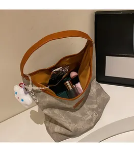 Sac hobo spacieux montrant l'intérieur avec parapluie, maquillage et anses en cuir brun