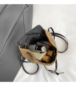Top view of a brown plush drawstring bucket bag showing interior space with phone and items