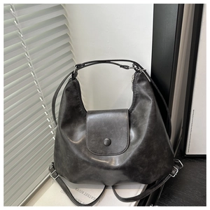 Dettaglio borsa hobo in finta pelle grigia vintage con manico e patta con bottone