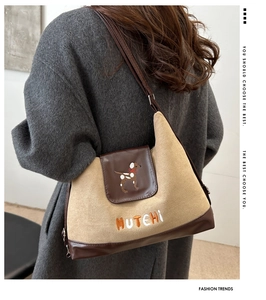 Detail of khaki suede crossbody bag featuring exquisite puppy embroidery and branding