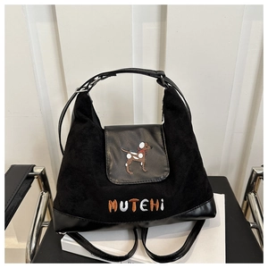 Detailed macro view of black crossbody bag showing matte texture and dog embroidery