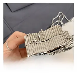 Macro shot of silver pleated mini bag with rhinestone base and durable metal hook