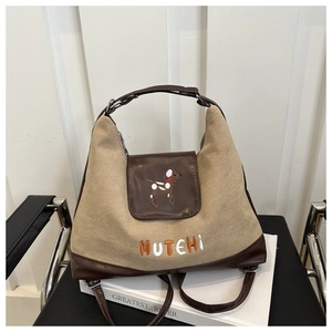 Close-up of cute dog embroidery and MUTEHI lettering on brown matte crossbody bag