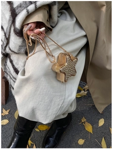 Dettaglio di una mini borsa da sera a forma di stella con strass e catena in metallo