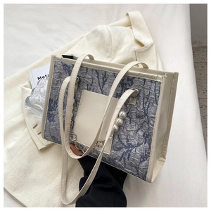 Detail of grey wrinkled tote bag with pearl metal chain and white leather pocket