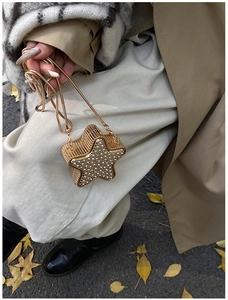 Dettaglio della borsa da sera dorata a forma di stella con strass e catena metallica