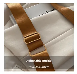 Detail of golden adjustable metal buckle on high-density brown nylon strap for shoulder bag