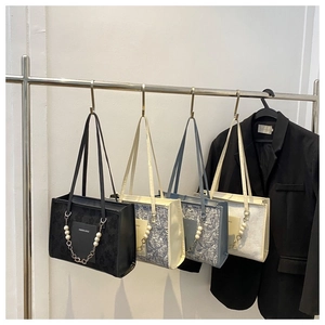 Detail view of stylish tote bags with pearl chains and jacquard texture in four colors