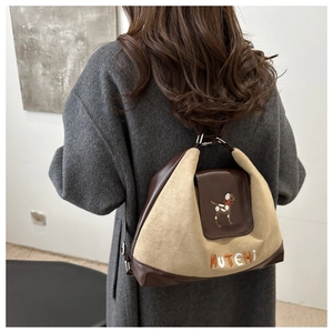 Detail of cute dog embroidery and MUTEHI text on beige matte contrast shoulder bag