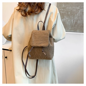 Detail showing plush brown mini backpack with drawstring flap and slim leather straps