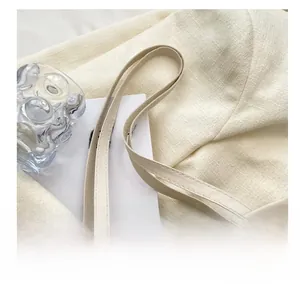 Detailed close-up of ivory shoulder bag featuring elegant floral embossed texture and stitching