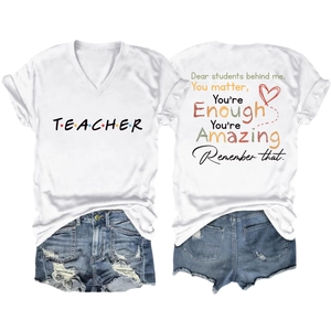 Flat lay of white V-neck T-shirt with TEACHER print and denim shorts set