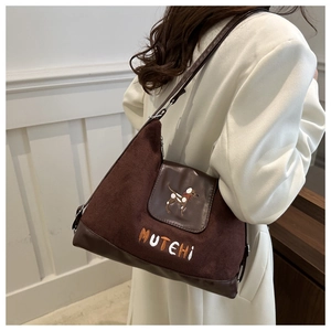 Detail of dark brown faux suede shoulder bag featuring a cute puppy embroidery