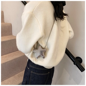 Detailed view of silver star shaped rhinestone crossbody bag with fine chain on model