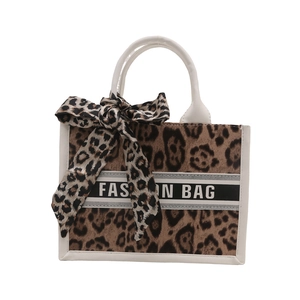 Brown leopard print tote bag with white trim and fashion bow on white background