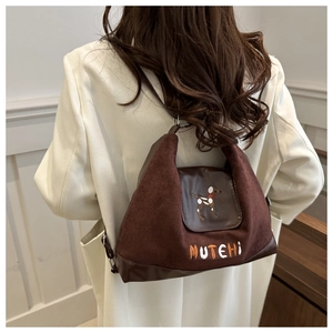 Detailed close-up of vintage brown suede stitching and cartoon hound embroidery on bag