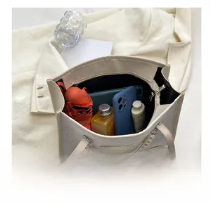 Detailed interior view of a cream tote bag with pearl chain showing large storage capacity