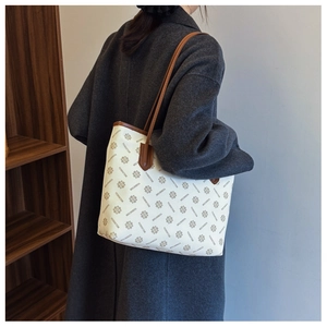 Close-up of printed pattern on tote bag with leather straps worn with wool coat