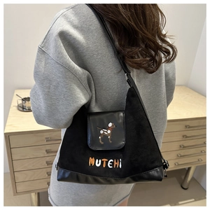 Detail of black canvas shoulder bag featuring cute dog embroidery and MUTEHI text