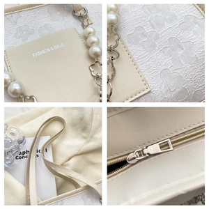 Detail view of cream tote bag with floral embossing and pearl chain shoulder strap