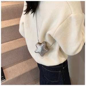 Close-up of a sparkling silver star-shaped mini bag with rhinestones and metal chain strap