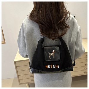 Close-up of black shoulder bag featuring cute dog embroidery and MUTEHI text detail