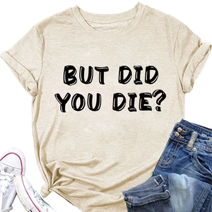 T-shirt beige con scritta BUT DID YOU DIE? stesa con jeans blu e scarpe bianche
