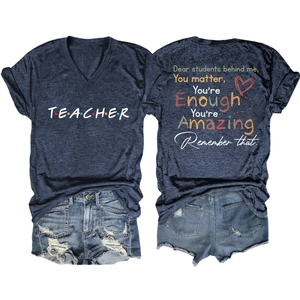 Flat lay of v-neck teacher t-shirt showing front logo and back motivational quote