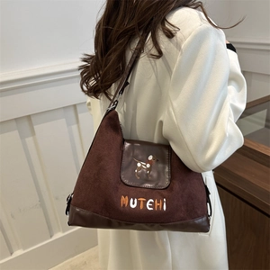 Dark brown suede tote bag with cartoon dog embroidery shown on a model side view